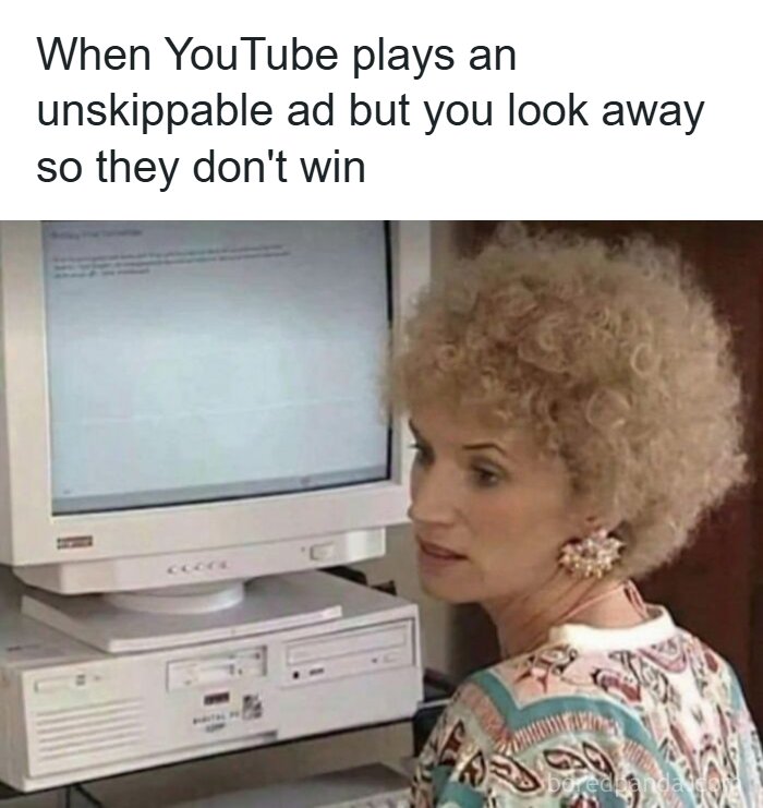 Woman with curly hair looking away from an old computer screen, illustrating a funny meme about skipping unskippable ads.