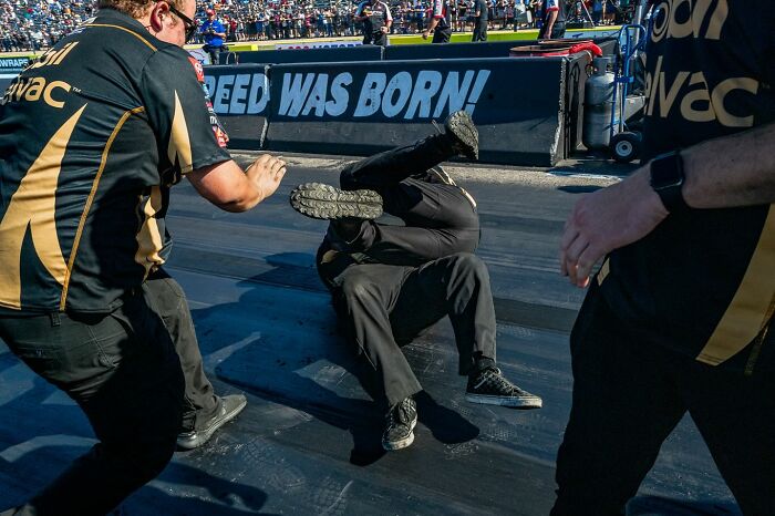 Man captured mid-fall on street in dynamic moment, showcasing authentic street photos by Perry Hall capturing life as it happens.