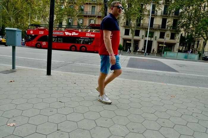 Street photographer captures perfect coincidences with a man walking in front of a Barcelona city tour bus.