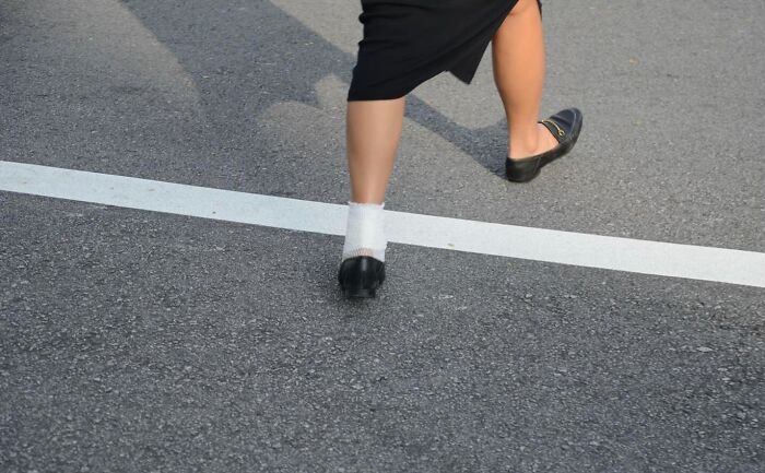 Person walking across street captured in perfect coincidence by street photographer at just the right moment