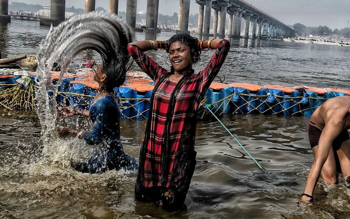 Children bathing joyfully in a river, capturing candid street photos that show humanity and tender moments worldwide.