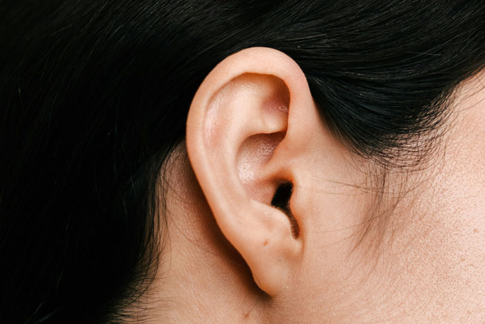 Close-up of an adult's ear, illustrating hygiene mistakes such as improper ear cleaning and buildup