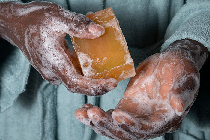Hands lathered with soap bar, illustrating hygiene mistakes adults often make