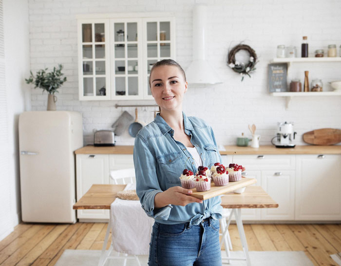 Young woman in a kitchen holding a tray of cupcakes during a dinner where SIL holds couple hostage and threatens car. Young woman in a kitchen holding a tray of cupcakes during a dinner where SIL holds couple hostage and threatens car.