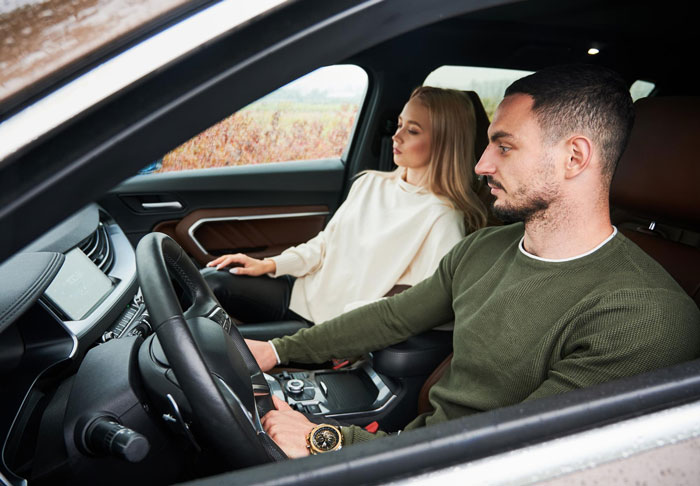 Couple sitting inside a car looking tense, illustrating SIL holding couple hostage and threatening to destroy car with food. Couple sitting inside a car looking tense, illustrating SIL holding couple hostage and threatening to destroy car with food.