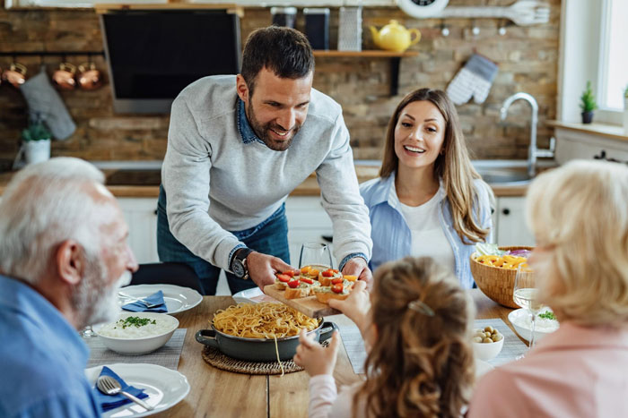 Family gathered at dinner table with SIL serving food, illustrating tense family dynamics and hostage situation at dinner.