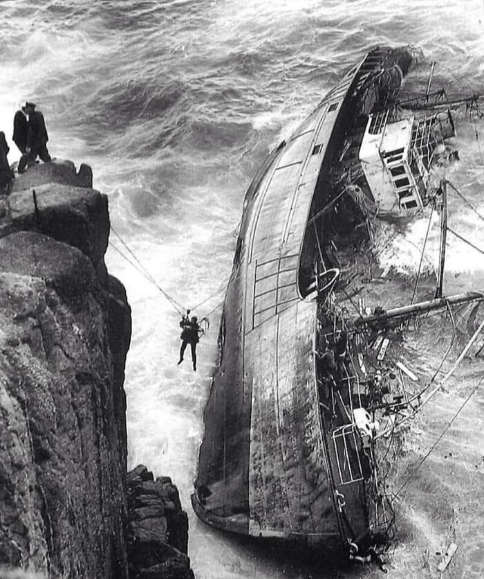 Rescue operation at a shipwreck on rocky coast, showing the sad and sometimes horrific history of humanity captured in photography.