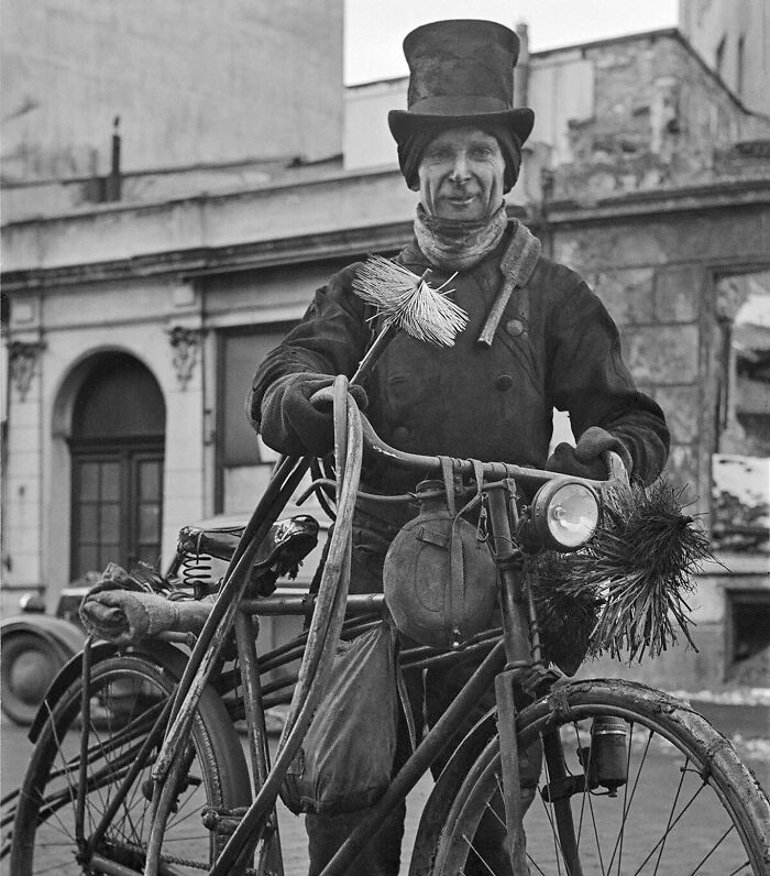 Black and white photo of a chimney sweep with a bicycle, representing the sad and beautiful history of humanity.