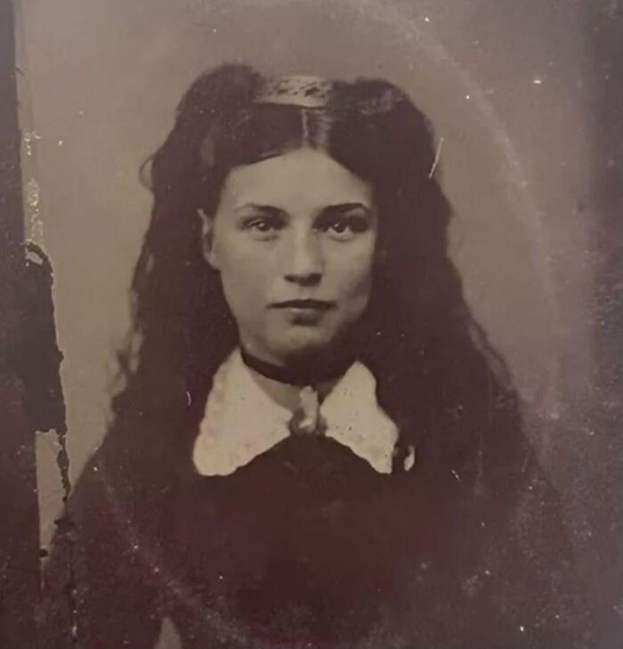 Black and white photograph of a young woman with long hair, capturing a poignant moment in the history of humanity.