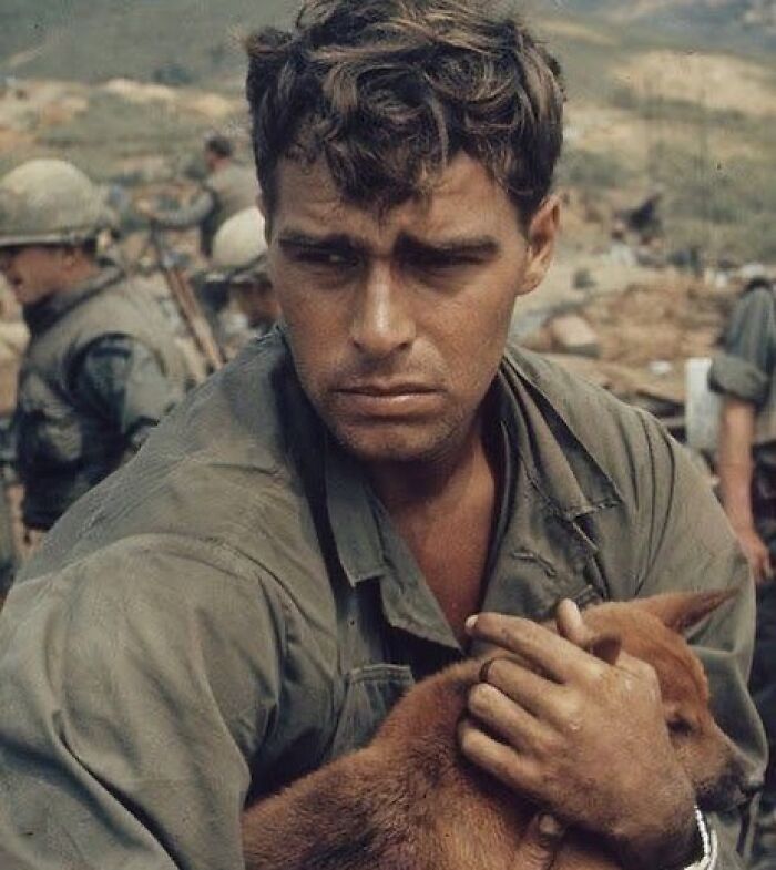 Wounded soldier holding a dog during war, capturing the sad and beautiful moments of humanity's history.