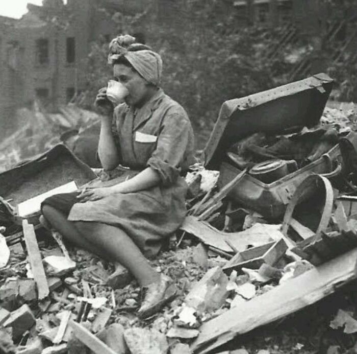 Woman sitting among ruins drinking tea, a powerful photograph reflecting the history of humanity’s struggles and resilience.