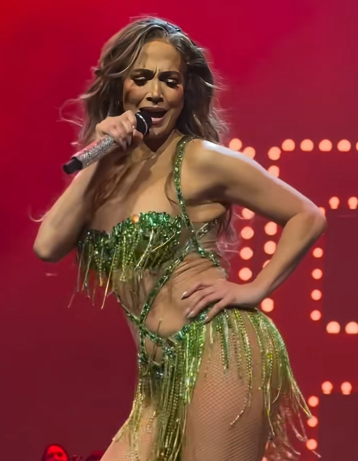 Jennifer Lopez performing on stage in a green fringe outfit, going viral after responding to dress her age comments. Jennifer Lopez performing on stage in a green fringe outfit, going viral after responding to dress her age comments.