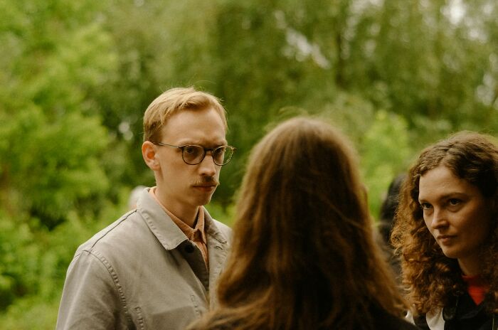 Three people talking outdoors, illustrating cultural differences in things normal in America but offensive elsewhere.