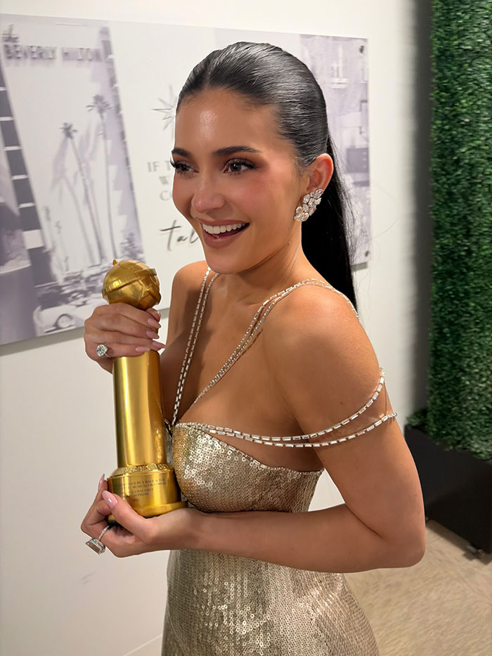Woman in a gold dress smiling and holding a Golden Globe award, related to Timothée Chalamet Golden Globes post news. Woman in a gold dress smiling and holding a Golden Globe award, related to Timothée Chalamet Golden Globes post news.