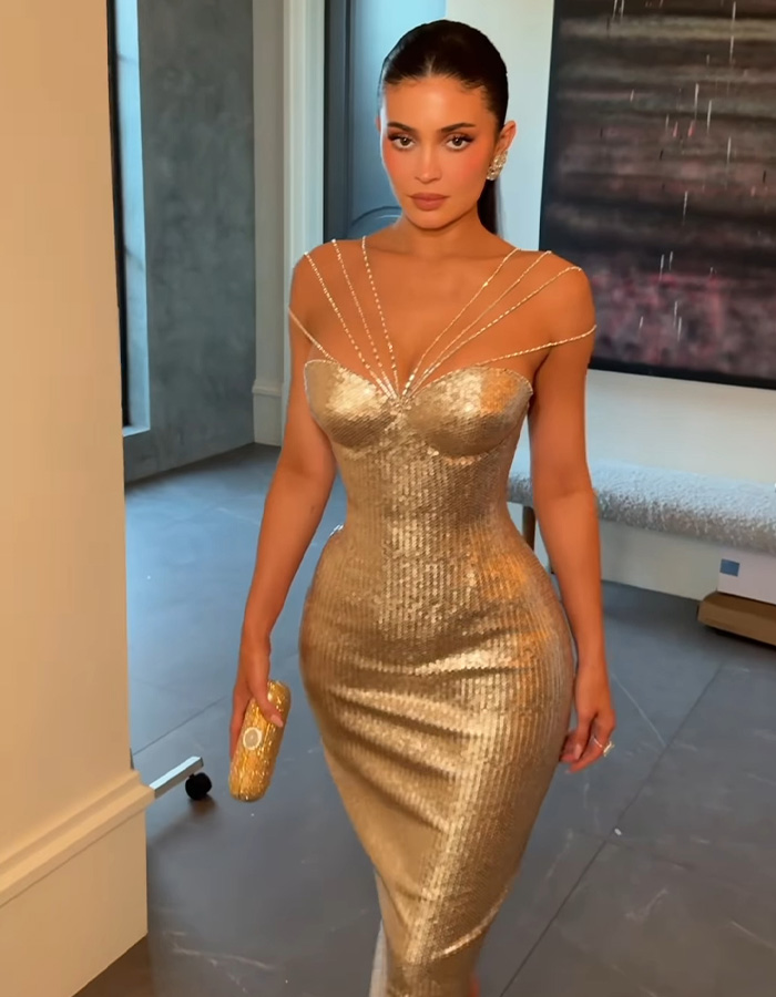 Kylie Jenner wearing a gold dress indoors before the Golden Globes seat photo sparks heated debate online. Kylie Jenner wearing a gold dress indoors before the Golden Globes seat photo sparks heated debate online.