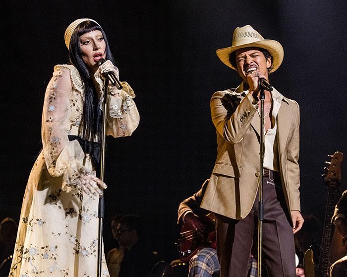 Two celebrities singing on stage under spotlight, highlighting strict rules celebrities follow during award shows.