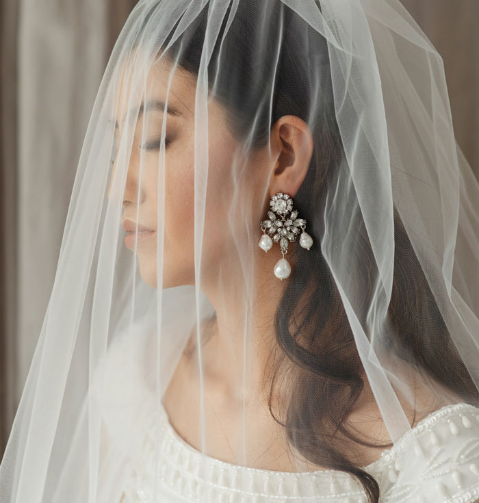 Teen bride with veil and pearl earrings, representing forced marriage and a plan for divorce. Teen bride with veil and pearl earrings, representing forced marriage and a plan for divorce.