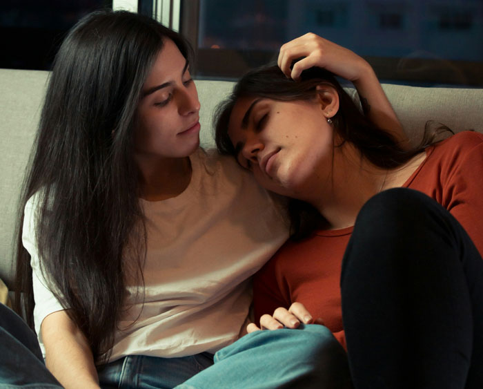 Teen woman comforting someone on couch in dimly lit room, reflecting a plan to make him divorce her after forced marriage. Teen woman comforting someone on couch in dimly lit room, reflecting a plan to make him divorce her after forced marriage.