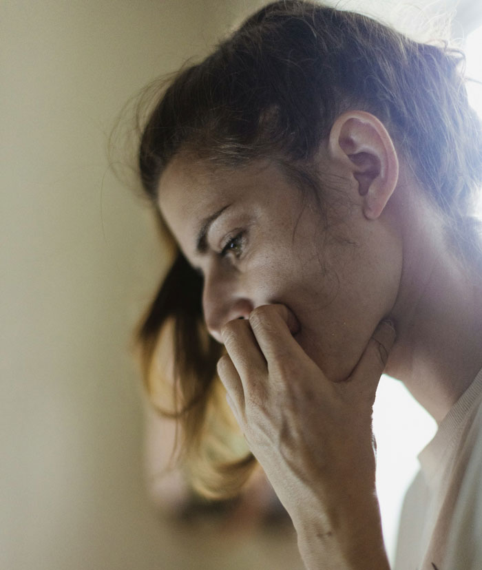Young woman looking distressed and thoughtful, reflecting the emotional impact of a messy divorce and family guilt.