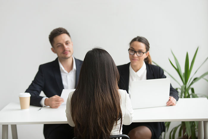 Business meeting with a woman facing two coworkers during a discussion about revenge in a professional office setting.