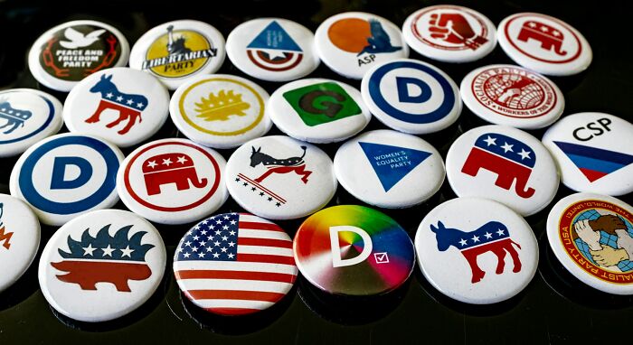 Assorted political party buttons with US symbols and logos, illustrating cultural differences in Europe and the US practices.