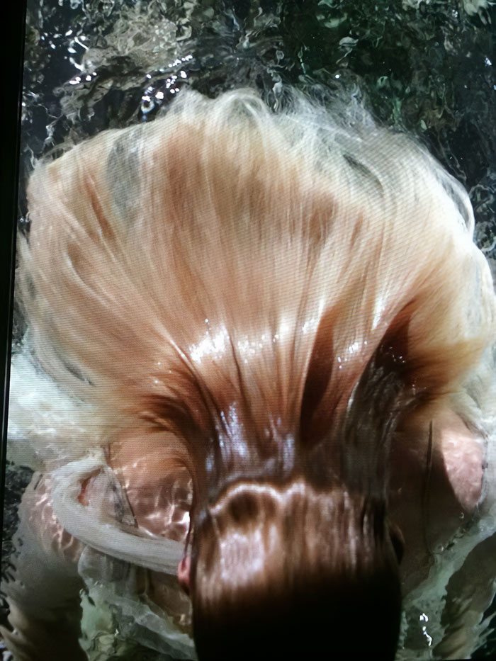 Underwater cover shoot featuring a woman with flowing hair submerged in water, capturing motion and light reflections. Underwater cover shoot featuring a woman with flowing hair submerged in water, capturing motion and light reflections.
