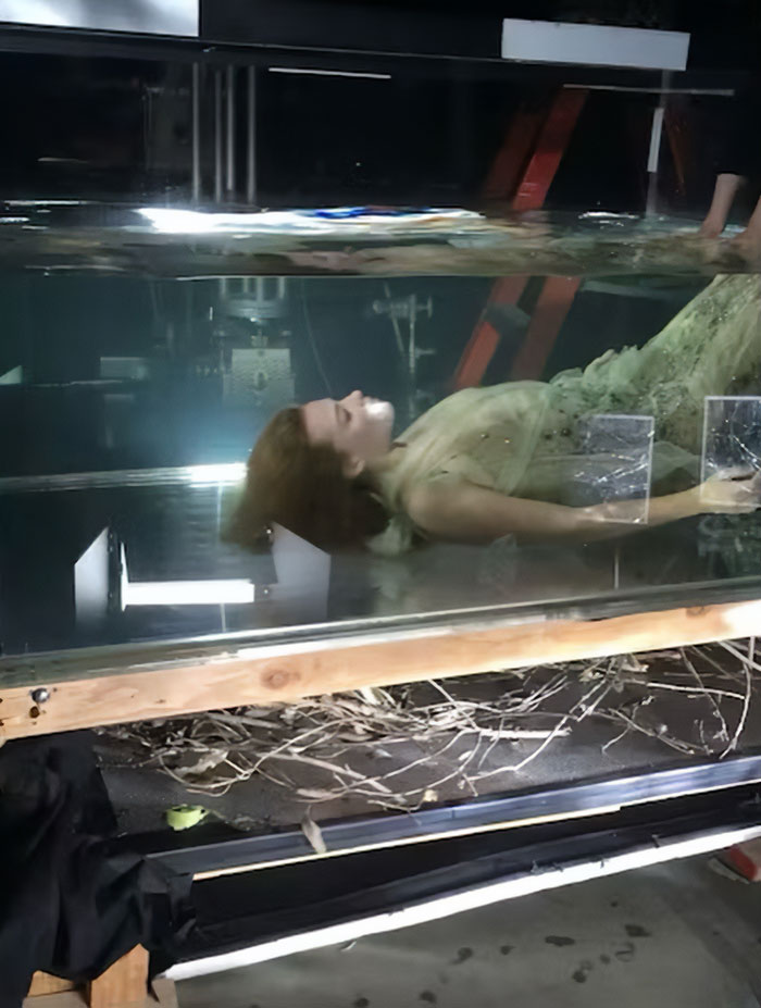Margot Robbie lying underwater in a dress during a controversial underwater cover shoot setup with visible studio equipment. Margot Robbie lying underwater in a dress during a controversial underwater cover shoot setup with visible studio equipment.