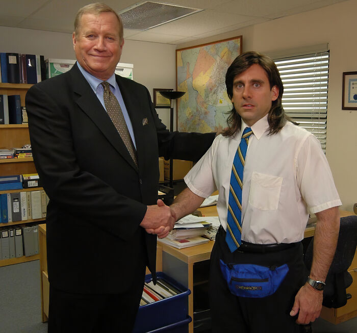 Two men shaking hands in an office, capturing a moment linked to accidental texts causing panic.