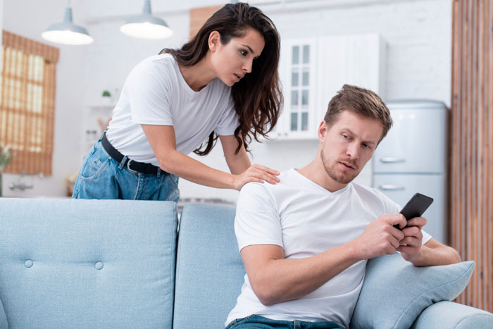 Man appears entitled and distant on phone while woman tries to calm him, illustrating mistreatment linked to mental issues.