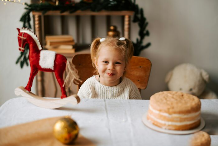 Toddler at birthday party with cake and decorations, capturing awkward moments with guest mom taking control.