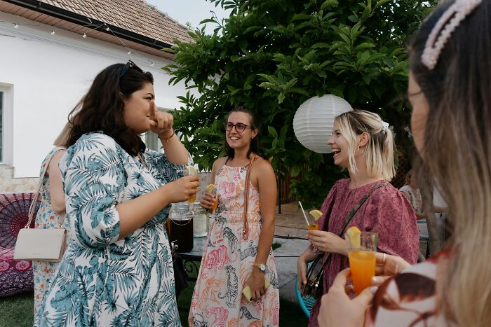 Guests at a b-day party socializing outdoors as a guest mom takes control and rearranges food on the table. Guests at a b-day party socializing outdoors as a guest mom takes control and rearranges food on the table.