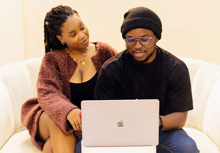Couple discussing wedding plans on a laptop as mother dictates wedding attire and groom contemplates refusal to marry.