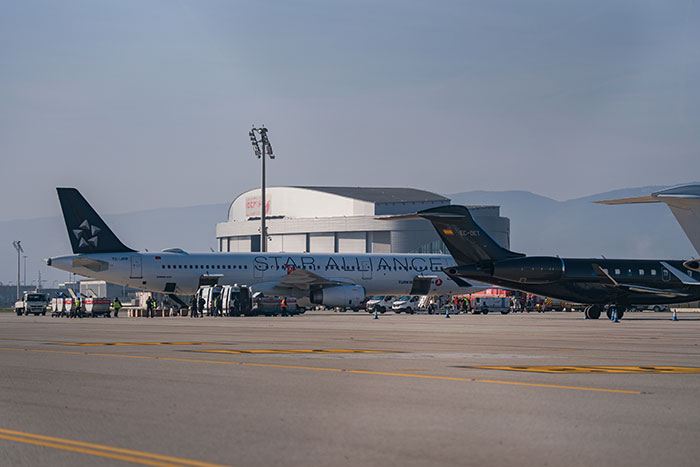 Passenger jet on runway with support vehicles nearby, illustrating fighter jets scrambled over WiFi hotspot name incident.