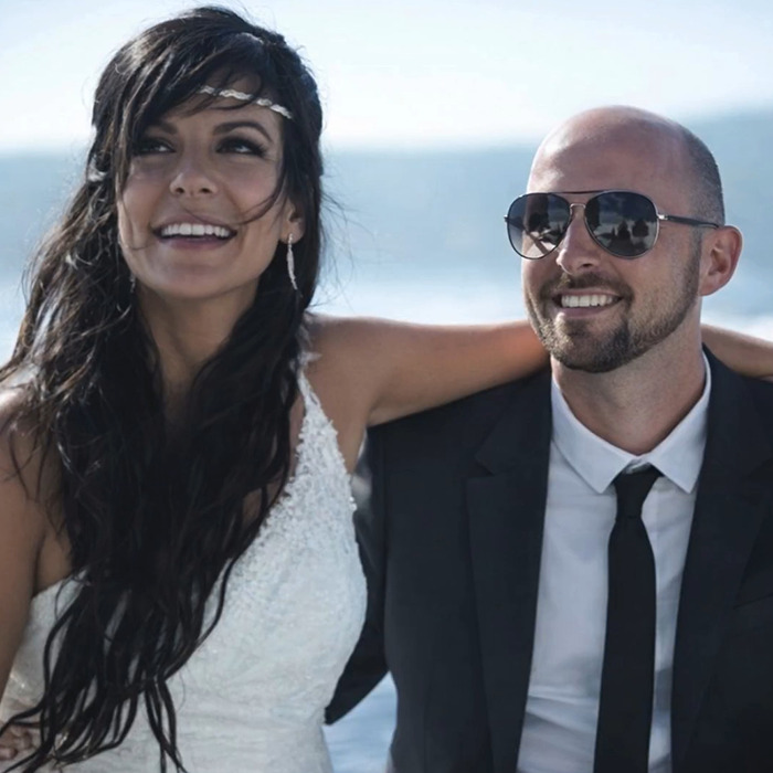 Couple smiling outdoors against a blue sky backdrop, unrelated to Swiss resort blaze or disturbing details.