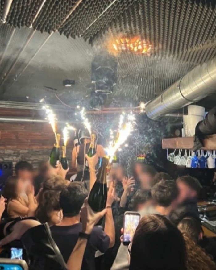 Crowd celebrates inside a Swiss resort with champagne and sparklers shortly before the horrific blaze that claimed nearly 50 lives.