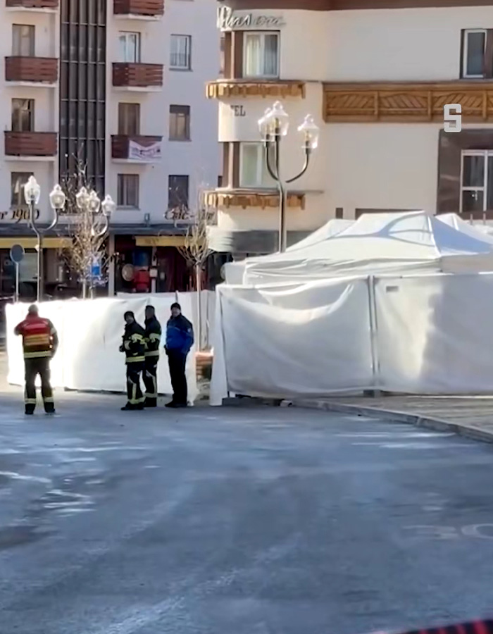 Firefighters and officials near a white tent in a Swiss ski bar area investigating possible cause of lethal fire incident. Firefighters and officials near a white tent in a Swiss ski bar area investigating possible cause of lethal fire incident.