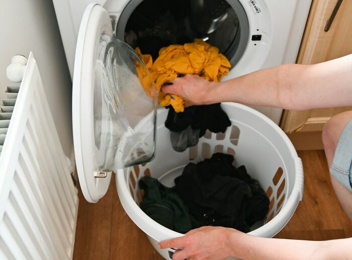 Person loading colorful clothes into a washing machine illustrating examples of a doctor doing something unethical with a patient.