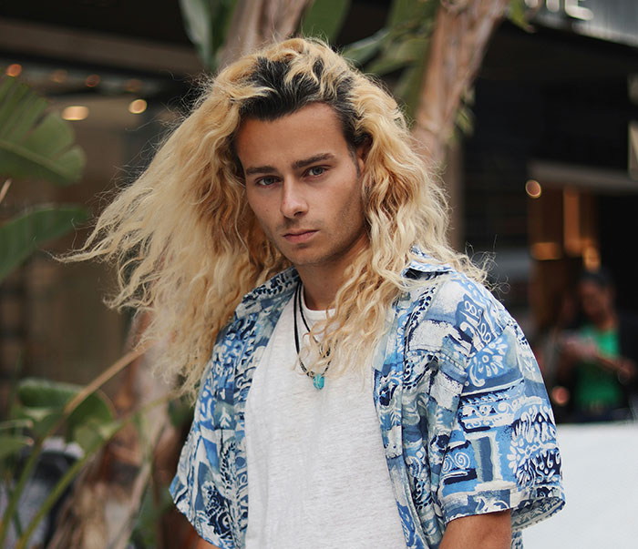 Young man with long blonde hair wearing a patterned shirt, illustrating the bald and divorced man shaming nephew story. Young man with long blonde hair wearing a patterned shirt, illustrating the bald and divorced man shaming nephew story.