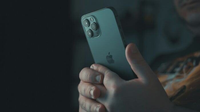 Close-up of a person holding an iPhone, illustrating overrated adult goals people chase that are a waste of time.