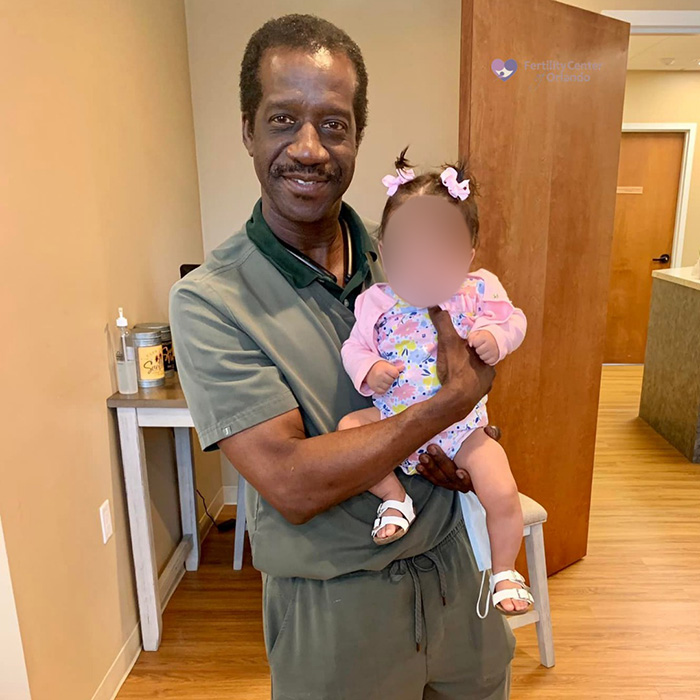 Man holding a baby in a fertility clinic setting, representing a shocking mix-up at a fertility clinic case. Man holding a baby in a fertility clinic setting, representing a shocking mix-up at a fertility clinic case.