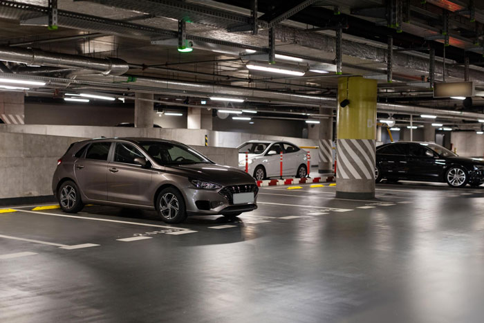 Car parked in an underground garage, illustrating new neighbor hijacking a person's parking place after refusal to switch spots.