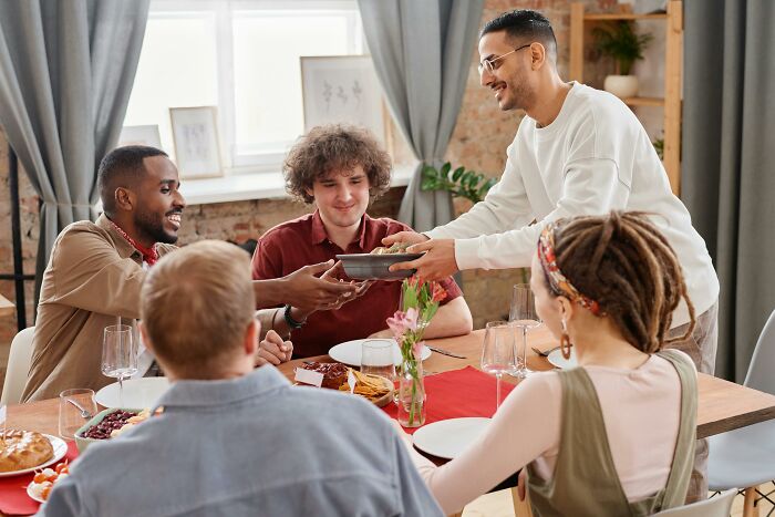 Group of friends sharing food and enjoying real-life cheat codes for better social gatherings around a dining table.