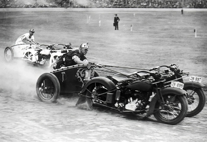 Vintage black and white photo of motorcycle sidecar racing capturing intense action from a historic country event.