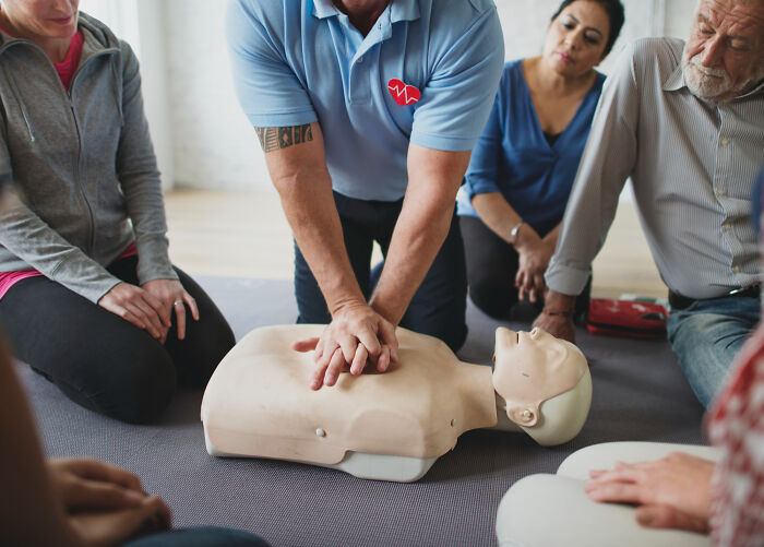 CPR training class demonstrating chest compressions on a mannequin, moments people faced learning lifesaving skills