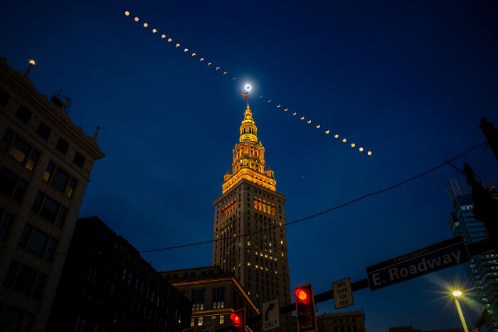 Night view of illuminated tower beneath a line of lunar eclipse phases, an incredible moment people faced