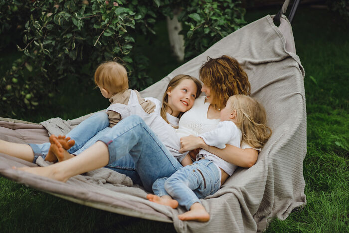 Mother and children relaxing together in a hammock, illustrating strange tales of folks who morphed unexpectedly.