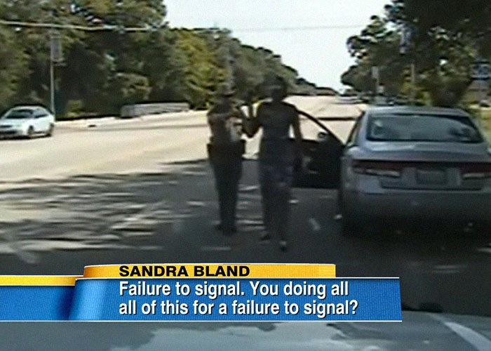 Police officer and woman near a car on a road, related to celebrity passings that people still don't believe were random.