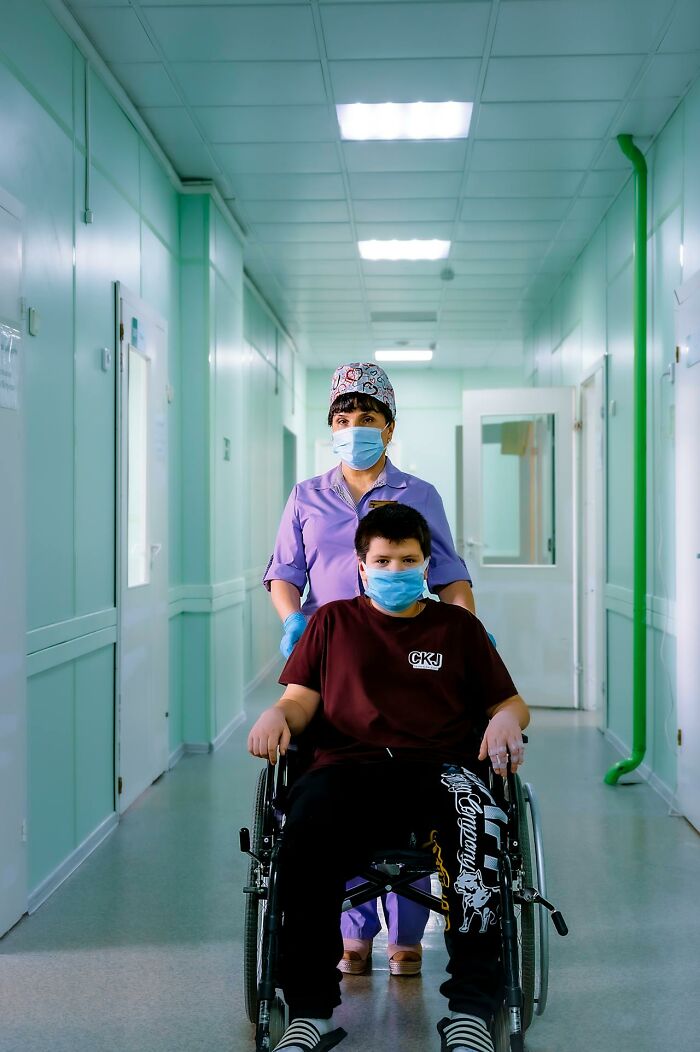 Nurse pushing patient in wheelchair down hospital hallway, representing really bad prognosis and medical miracles.