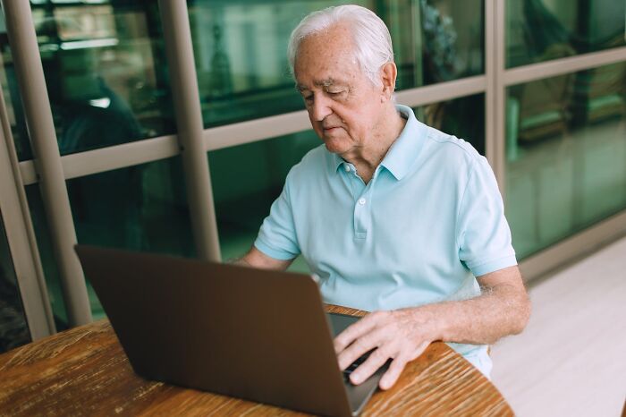 Elderly man using laptop indoors reflecting on things that shocked people after they got out of prison.