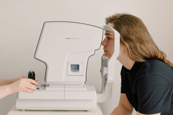Patient undergoing eye exam with medical equipment, highlighting unexplainable medical events and bad prognosis.